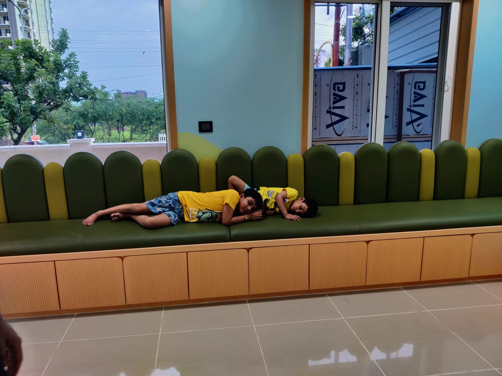Child resting on a sofa in the pediatric waiting area at Damyanti Devi Hospital